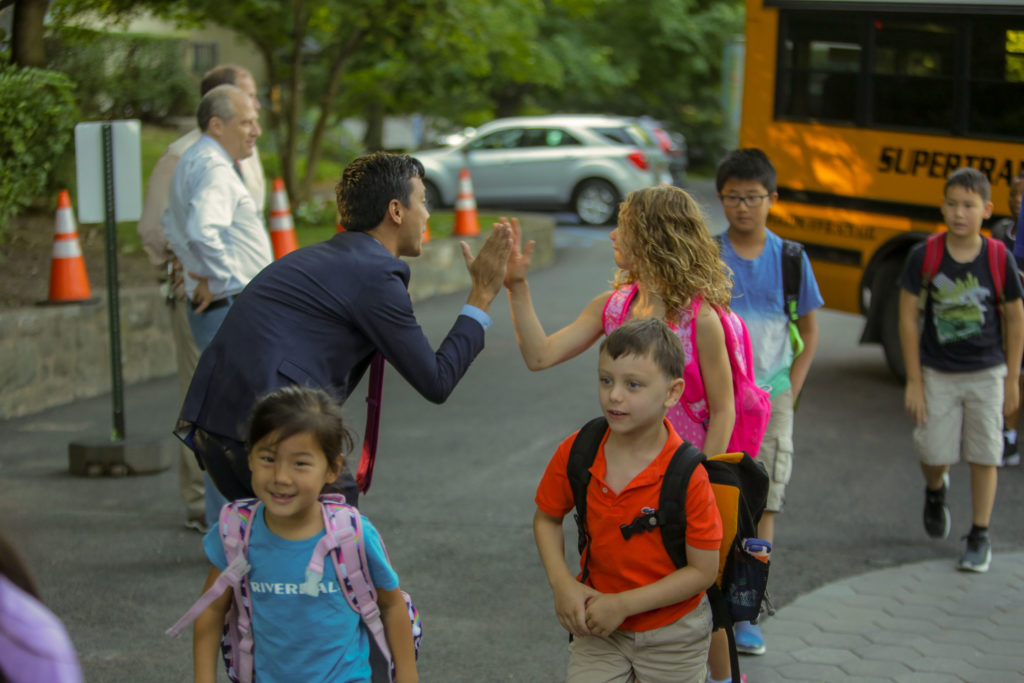 Dr. James Duval, head of the Lower School, greets children as they arrive in the morning.