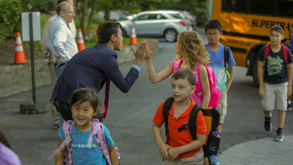 Dr. James Duval, head of the Lower School, greets children as they arrive in the morning.