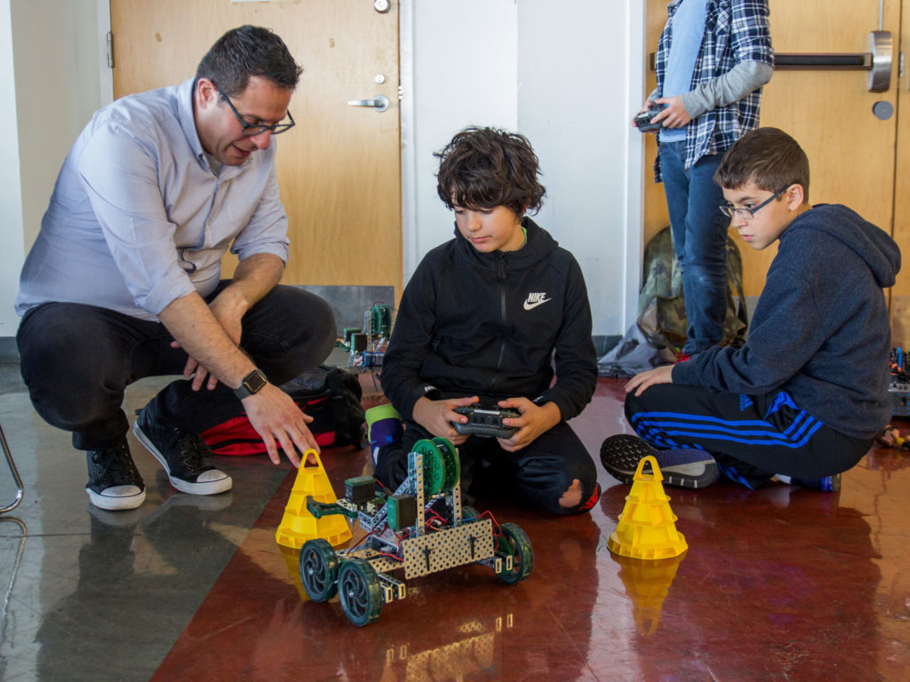 Andrew Abate, head of the Computer Science department, works with students on a robotics activity