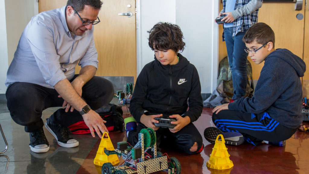 Andrew Abate, head of the Computer Science department, works with students on a robotics activity.