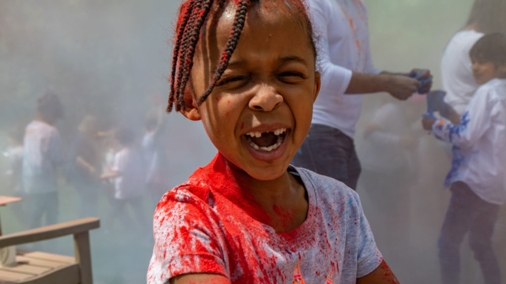To celebrate Holi, the Indian and Nepali "festival of colors," students throw colored powder in the air.