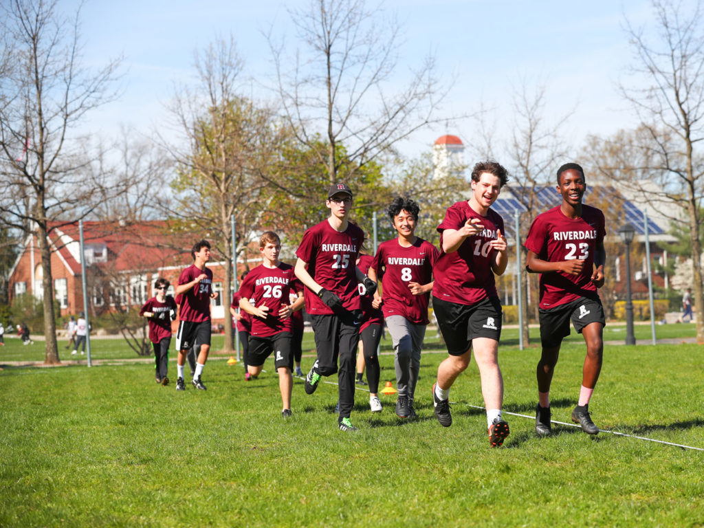 The Ultimate Frisbee team warms up on Alumni Field located at the center of the Hill Campus.