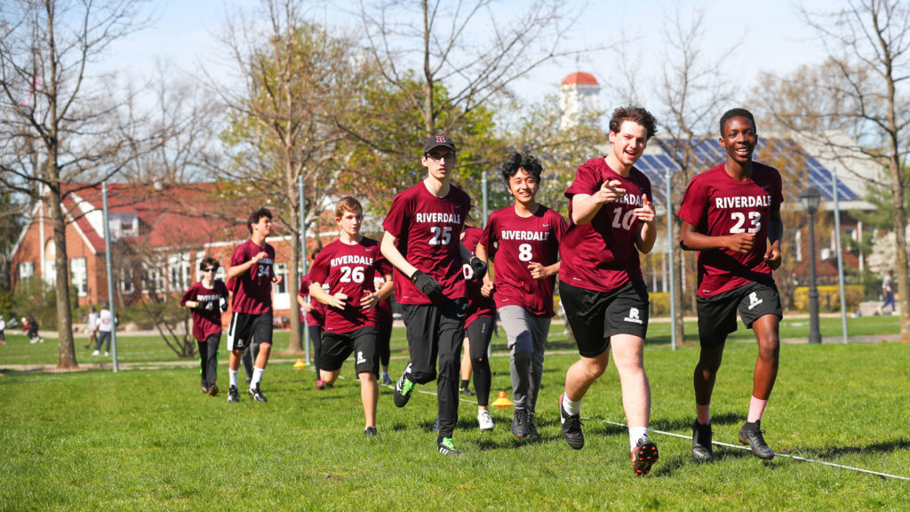 The Ultimate Frisbee team warms up on Alumni Field located at the center of the Hill Campus.