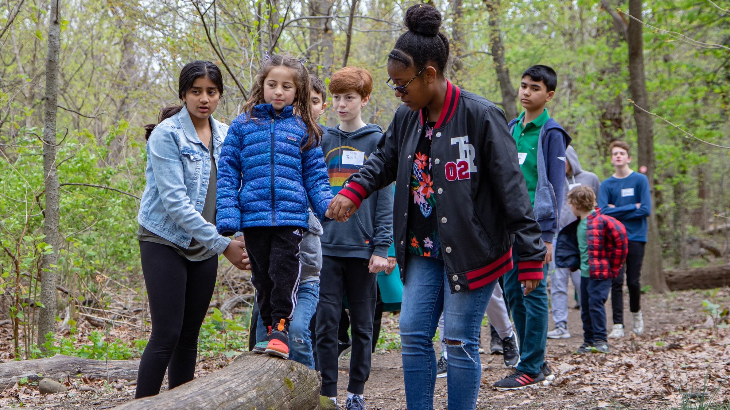 Eighth graders lead kindergarteners on a nature walk in Riverdale Park, which runs alongside the River Campus.