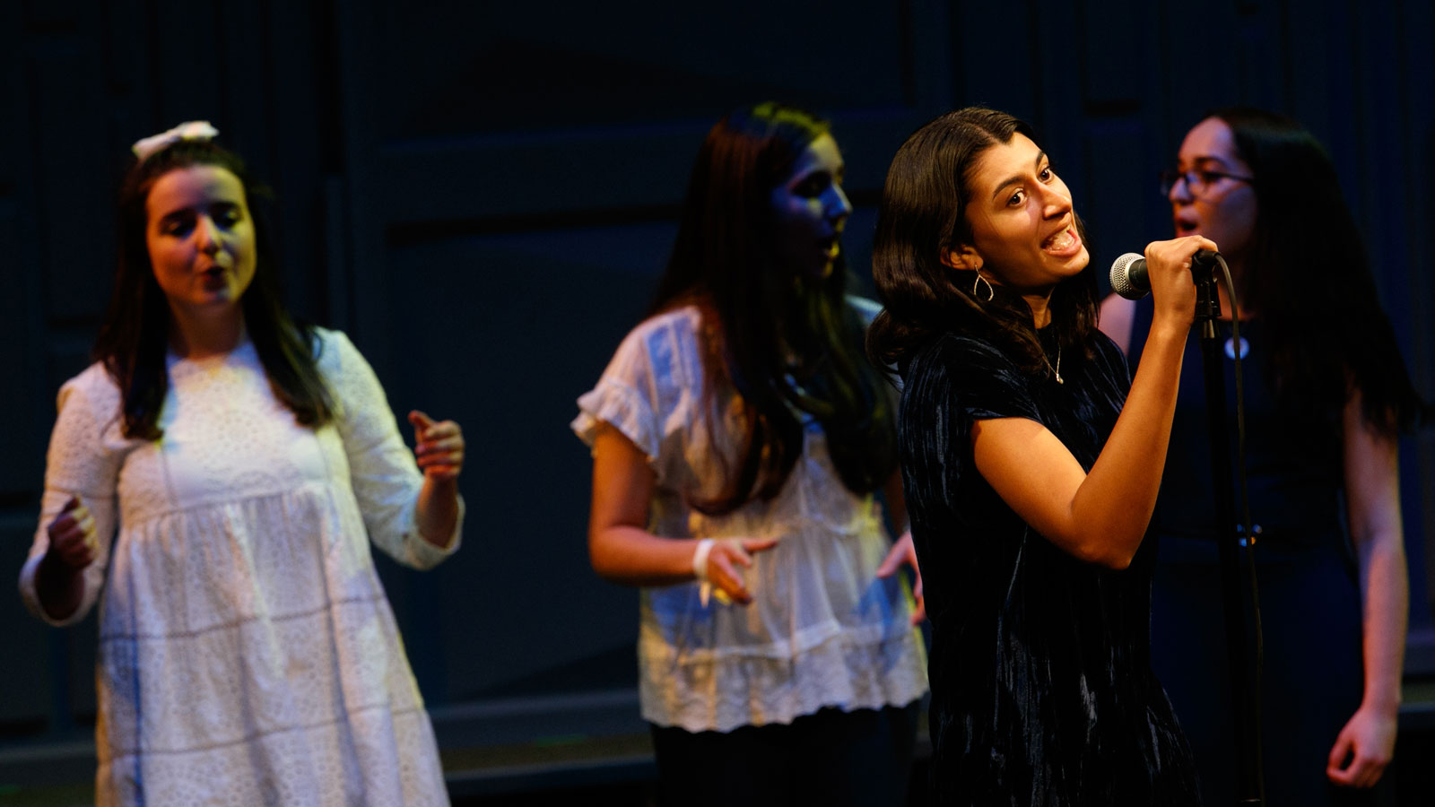 Riverdale's female a capella singing group performs at a concert.