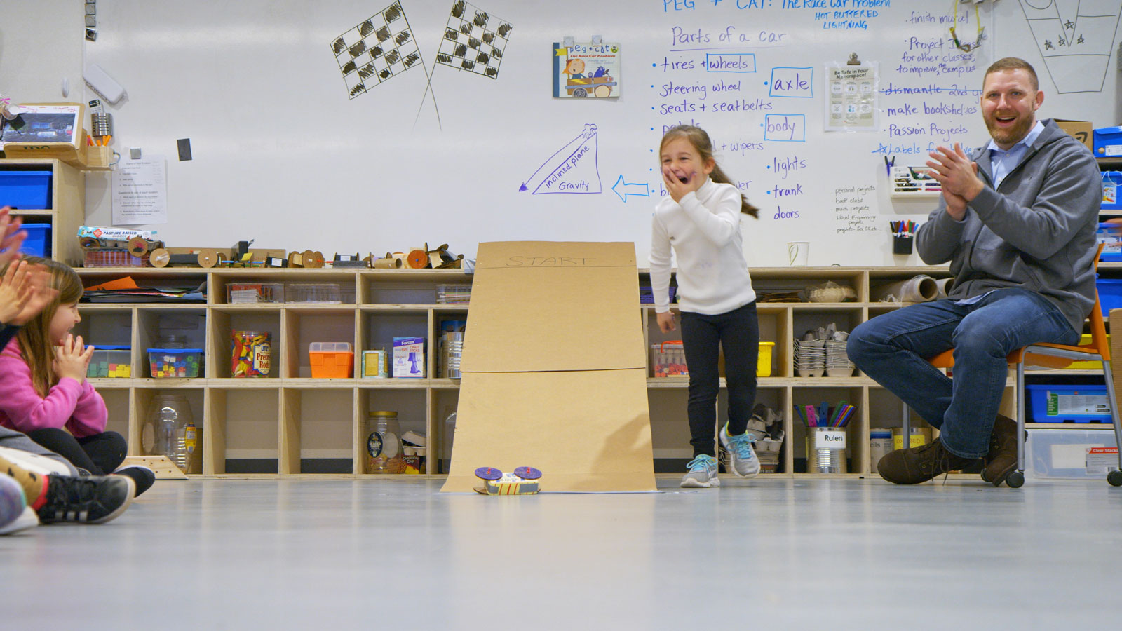 First grade students test drive the cars they built out of recycled materials.