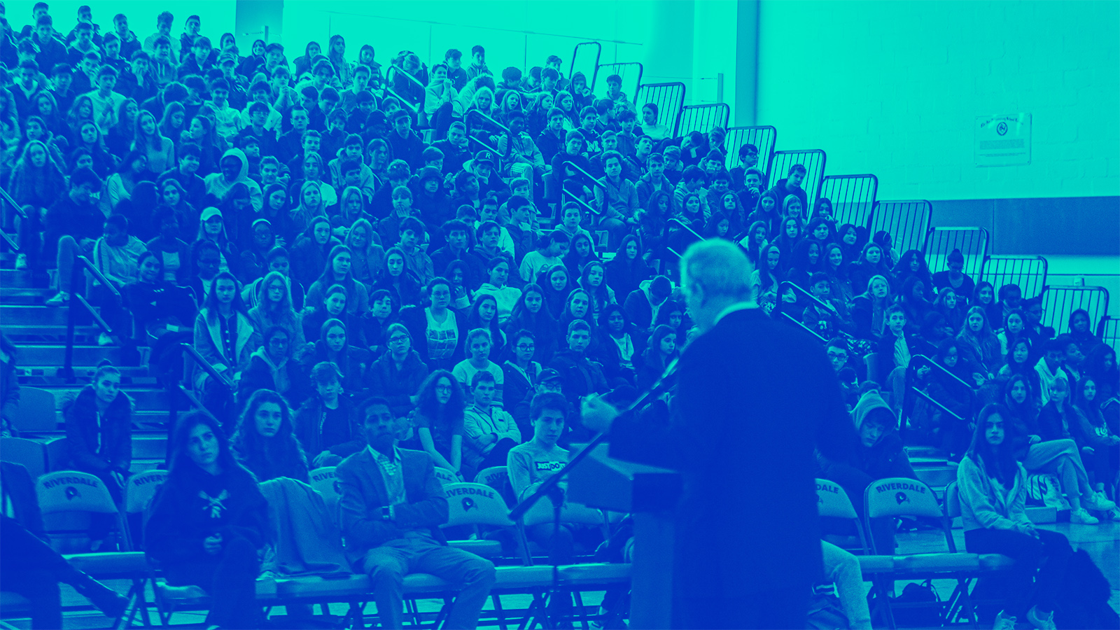 Bleachers full of students at Upper School assembly listening to Head of School Dominic Randolph