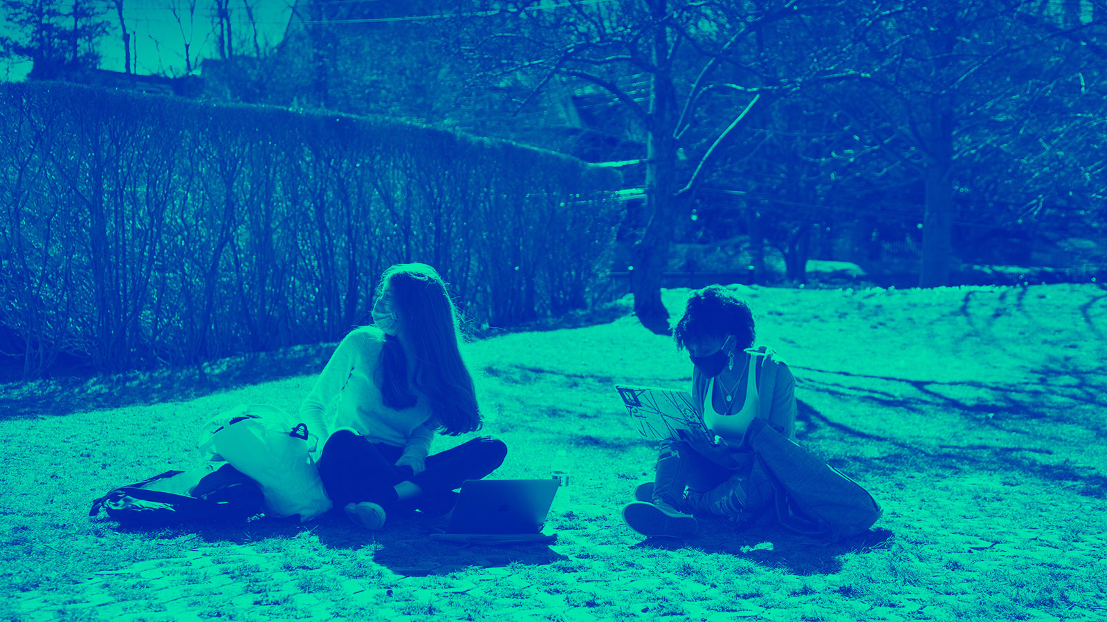 Two Upper School students study on Jones Lawn in the warm weather. 