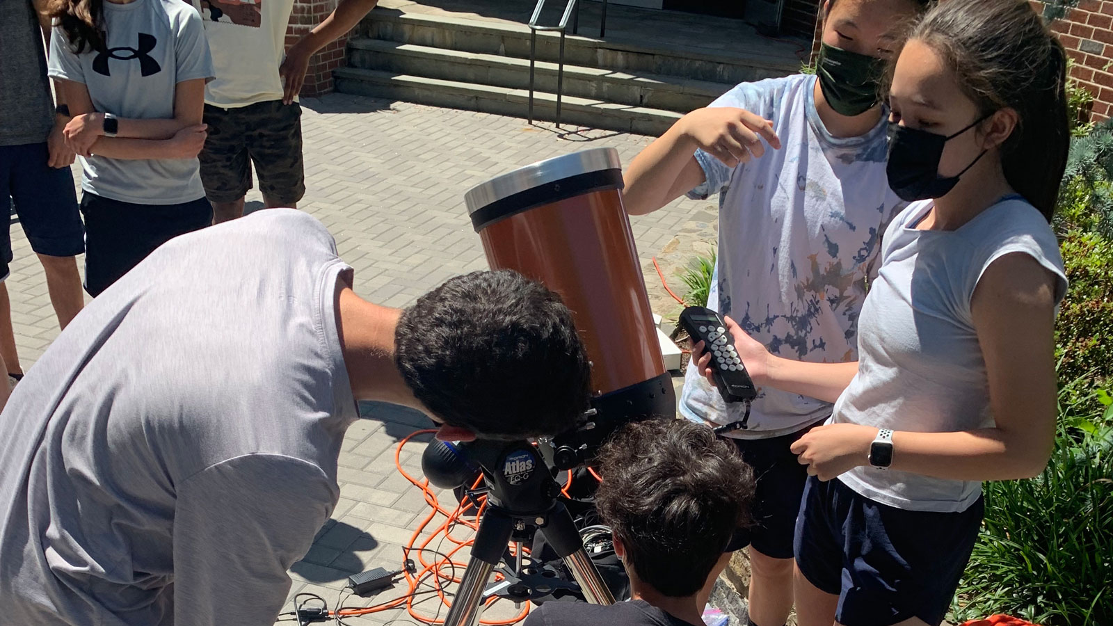 Students in Riverdale's summer astronomy program observe sunspots through a telescope set up on the Hill Campus and fitted with a solar filter.