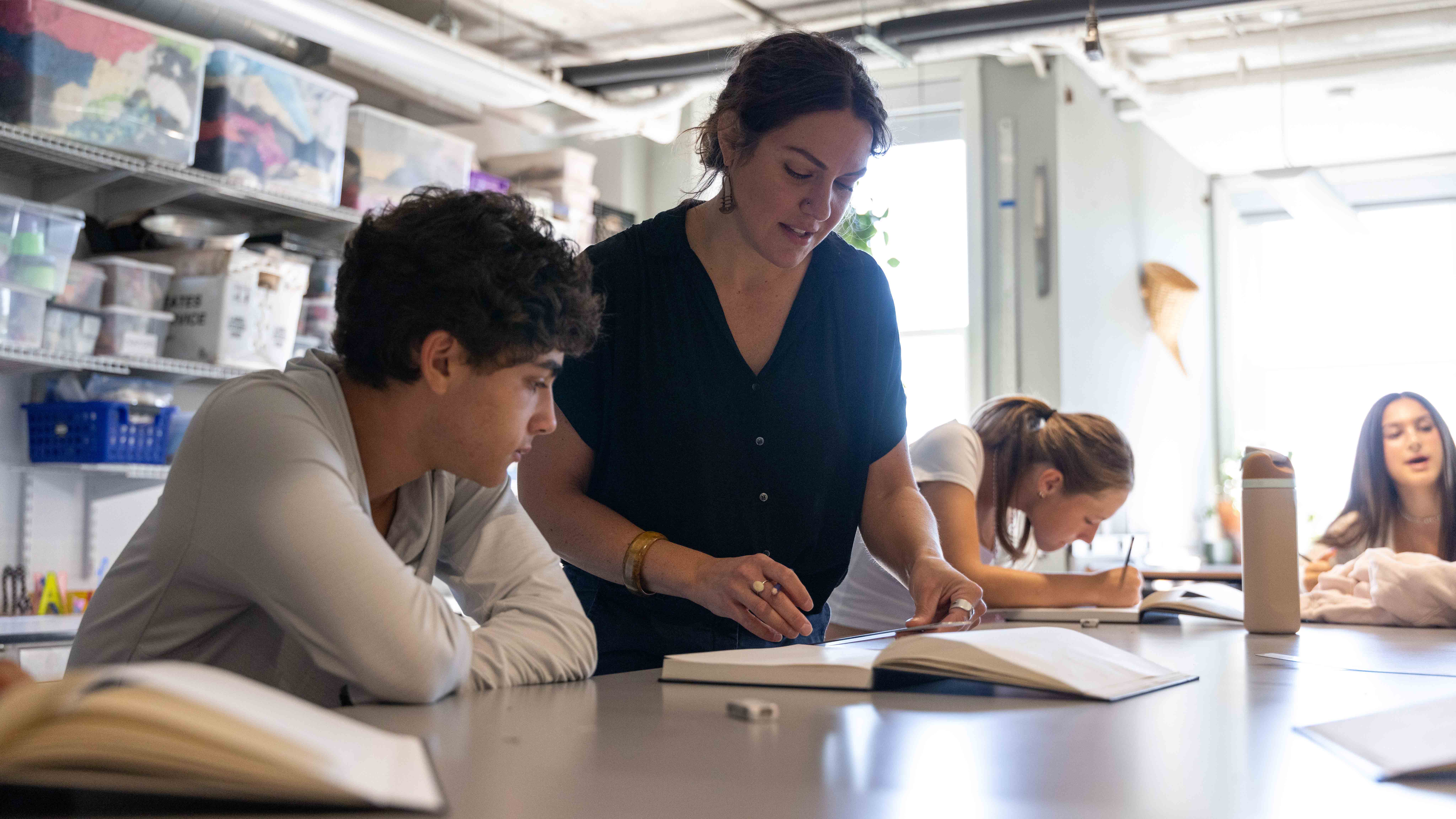 A teacher assists a student in class
